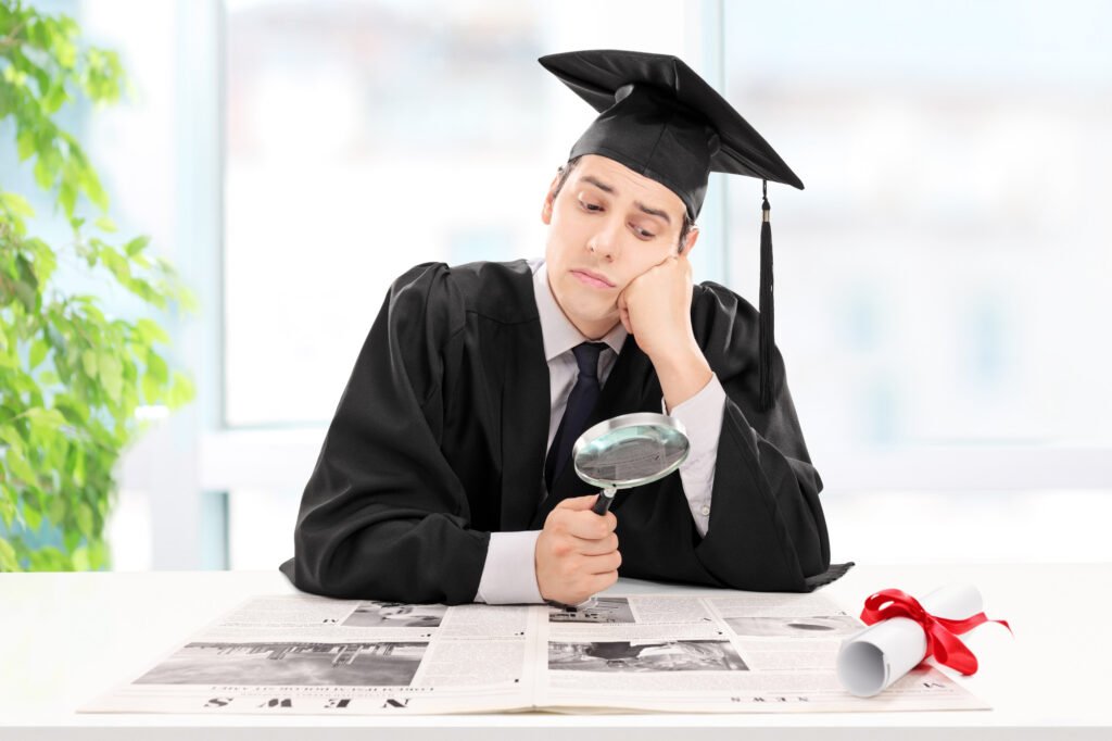 Student looking for a job in a newspaper at home with a magnifying glass