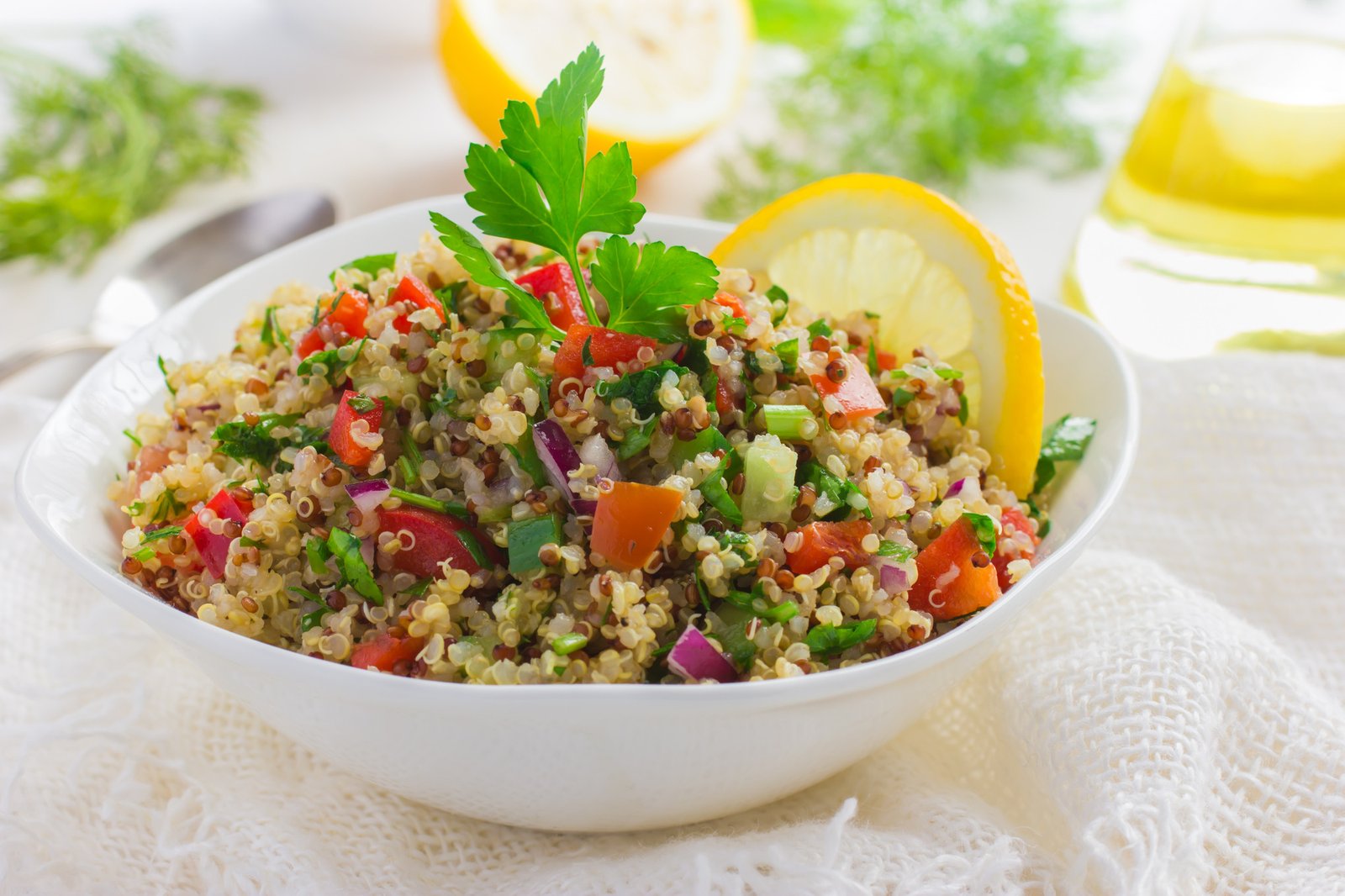 Tabbouleh salad with quinoa, parsley and vegetables on white background