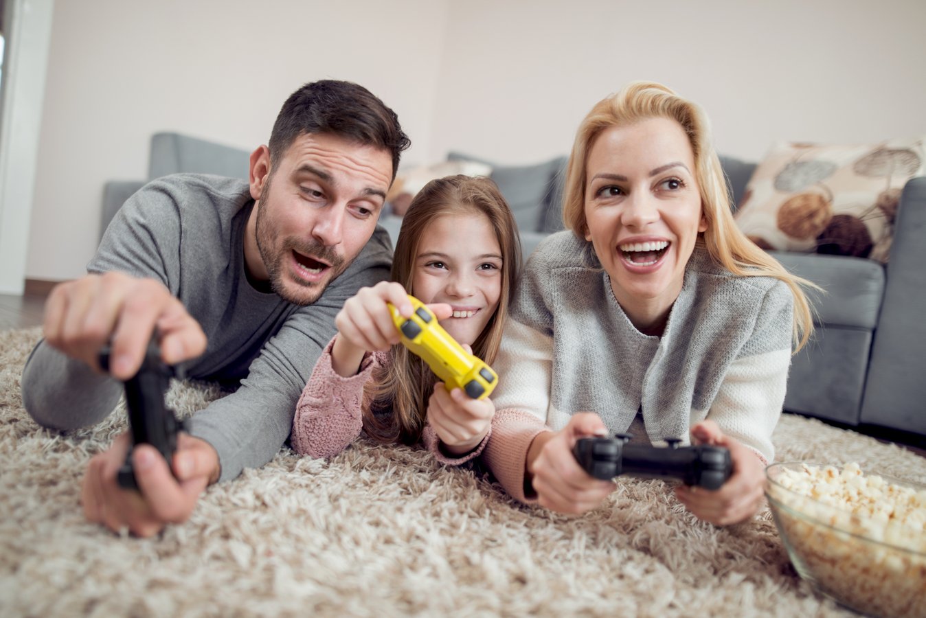 Playful family playing video games together in living room.
