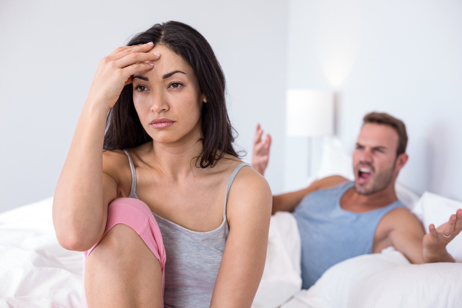 Couple in to argument on bed in their bedroom