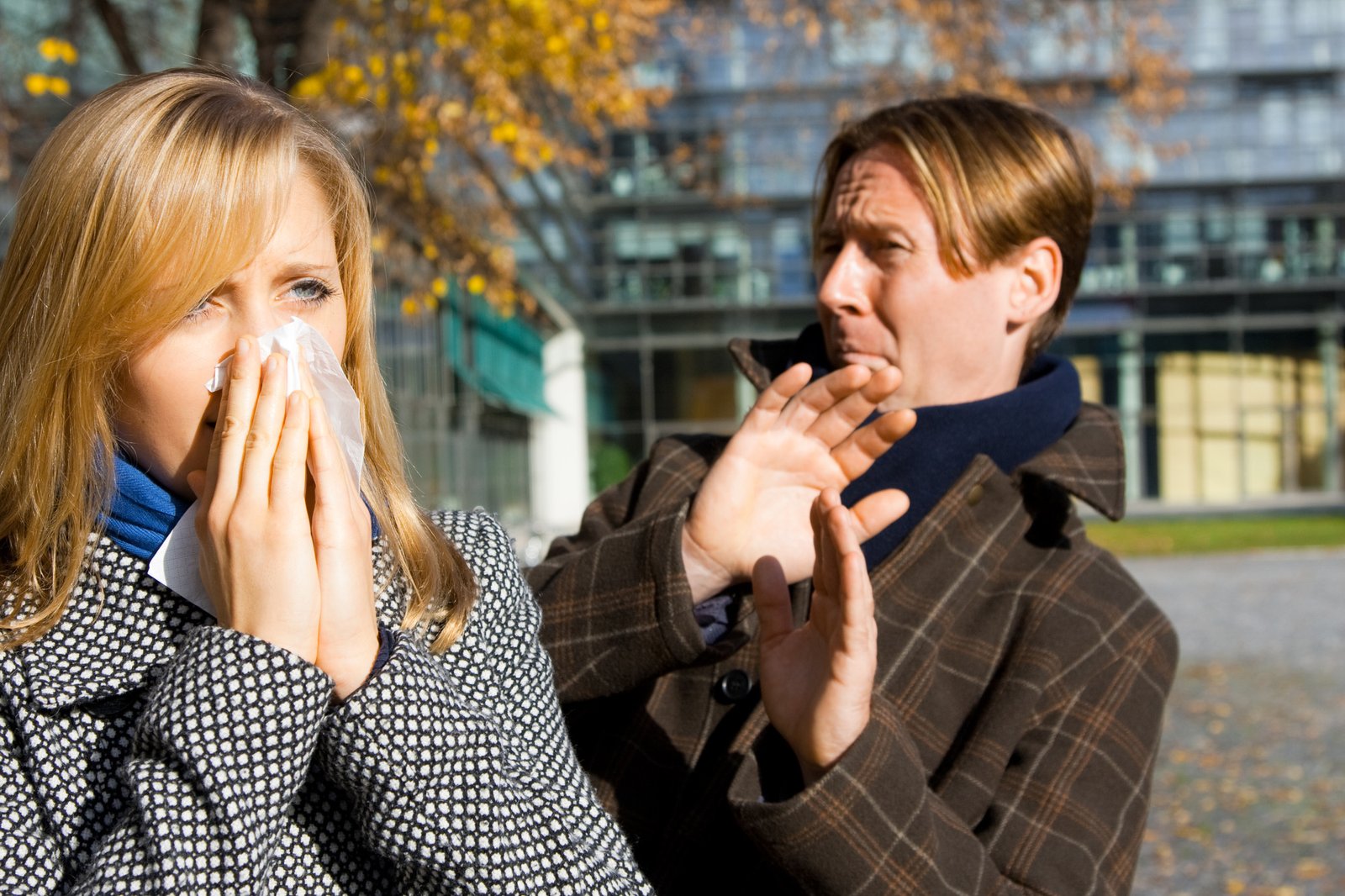 two people outdoors, extremely afraid to catch the flu from one another
